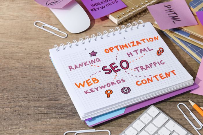 A spiral notebook with an SEO plan, with handwritten words such as "ranking", "HTML", "traffic", "content", and "keywords", to answer the question "How do I optimize SEO on Etsy?"