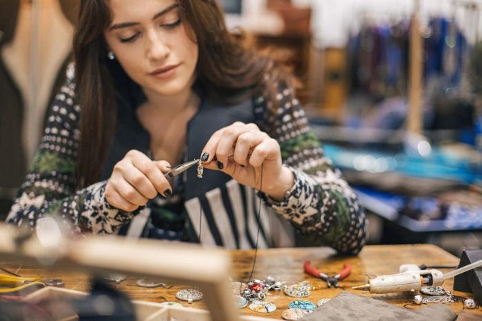 Woman is working on her handmade jewellery products that she sells on her Etsy shop, since consistency matters for Etsy SEO optimization