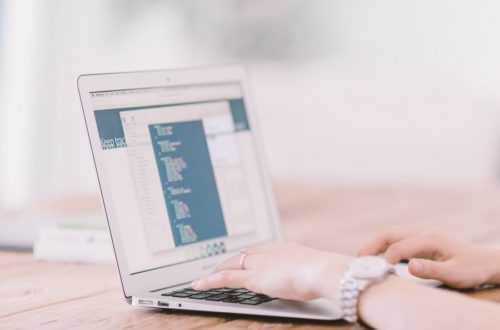 Woman's hands type in a notebook, she's learning how to improve WordPress security in 9 steps using a WordPress security checklists, searching for the best WordPress security plugins, and hardening WordPress.